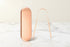 Auralis tongue scraper designed for effective tongue cleaning and breath freshening, featuring a sleek rose gold finish.